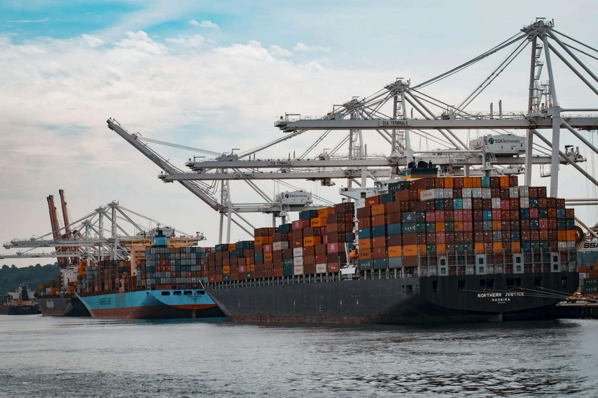 Container ships and cranes at major port representing global trade flows